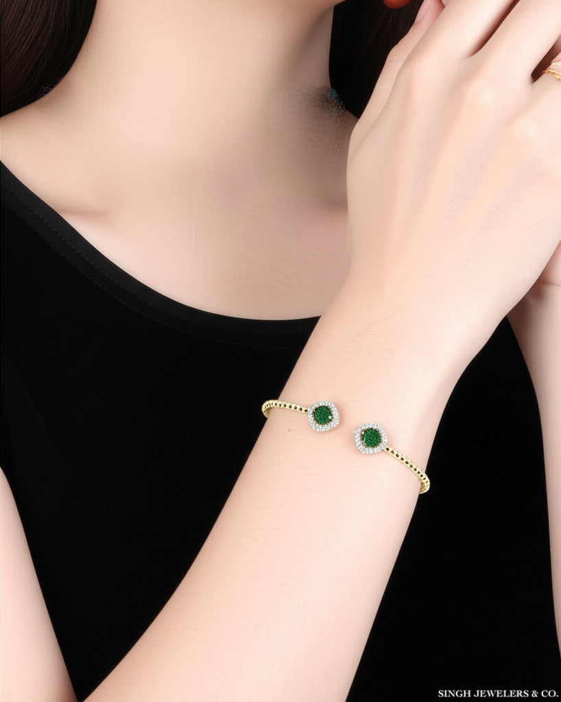 Woman wearing 1/4CTW natural diamond and emerald 5mm round ladies bangle
