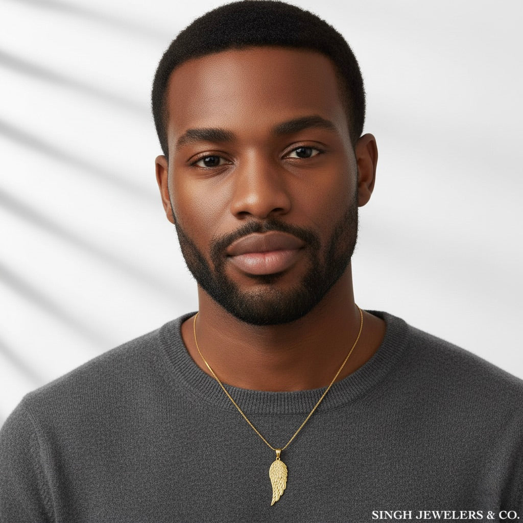 Man wearing a gold necklace with a leaf pendant against a neutral background