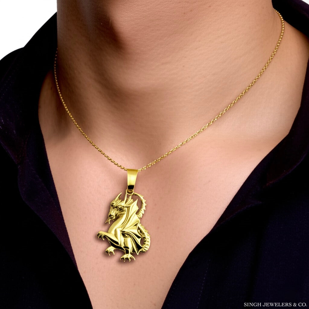 Gold necklace with a lion pendant on a person wearing a black shirt.