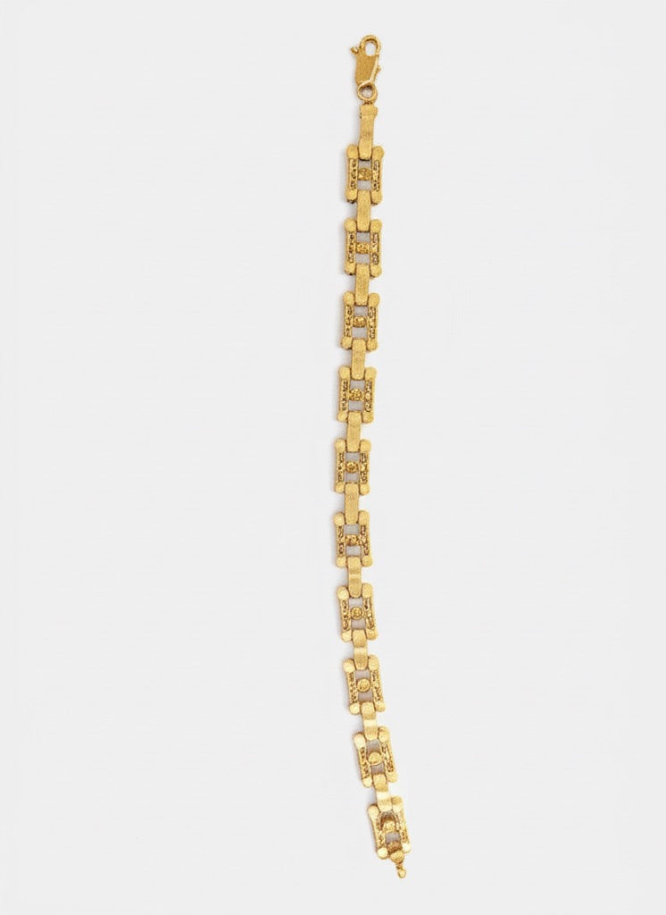 Gold bracelet with diamond accents on a white background