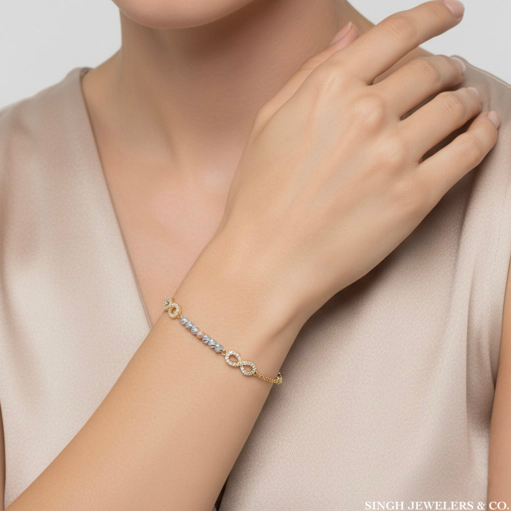 Gold bracelet on a model's wrist with a neutral background
