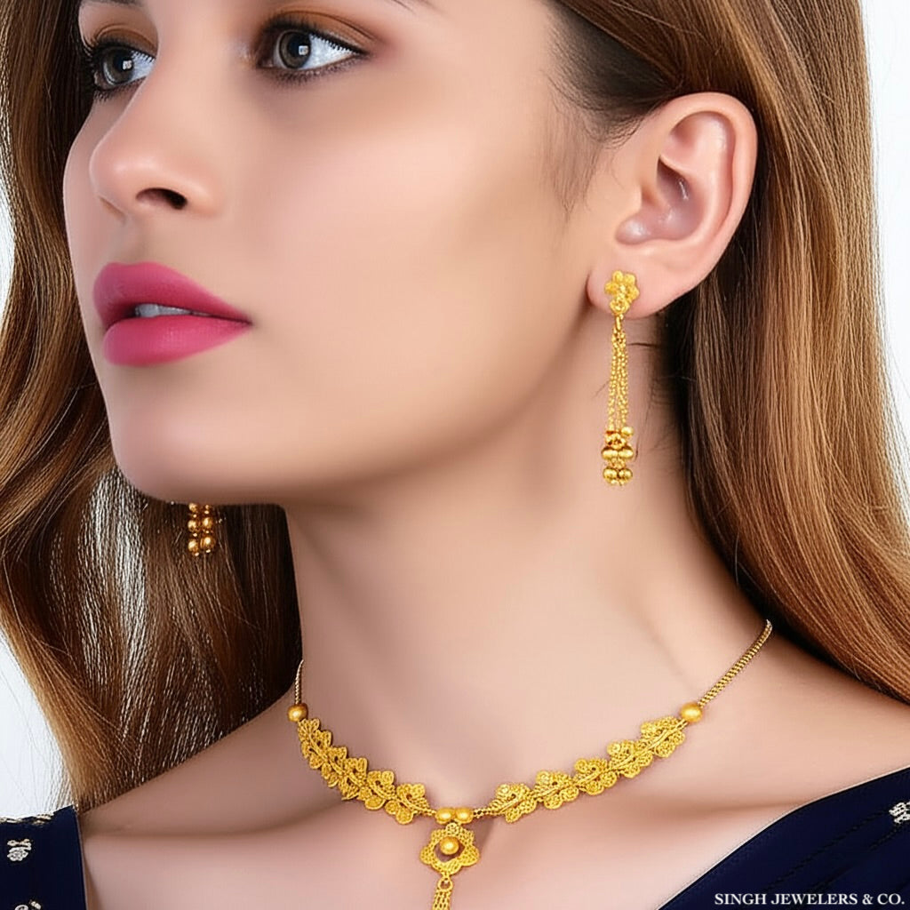 Woman wearing gold necklace and earrings with Singh Jewelers & Co. branding.