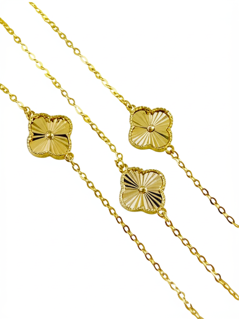Gold necklace with clover-shaped pendants on a white background