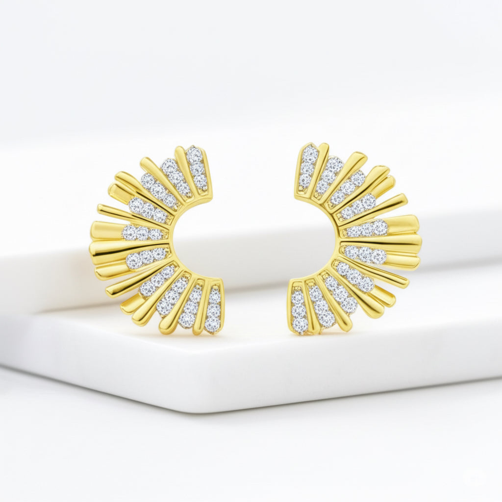 Gold earrings with diamond accents on a white surface