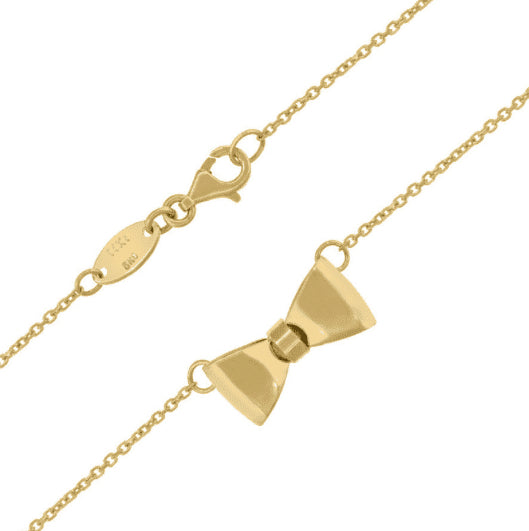 Close-up of polished bow charm on 14K yellow gold necklace