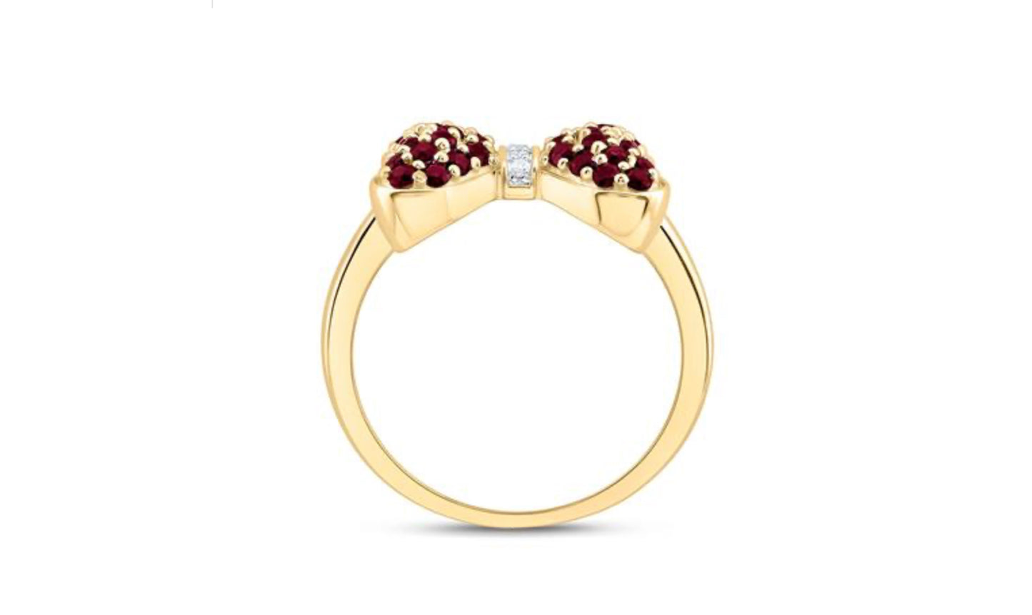 Gold ring with red gemstones and a diamond on a white background