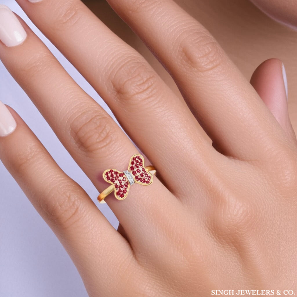 Gold ring with red gemstones on a hand, branded 'Singh Jewelers & Co'.