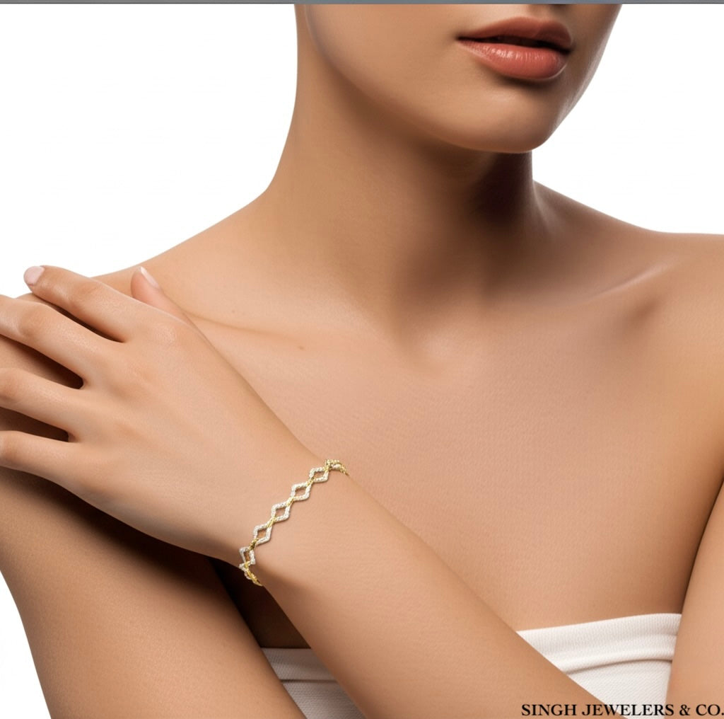 Gold bracelet on a model's wrist with a neutral background
