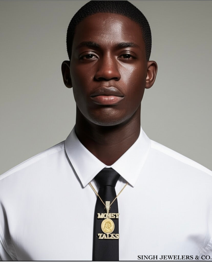 Man wearing a white shirt, black tie, and gold necklace with 'Money Talks' pendant on a gray background.