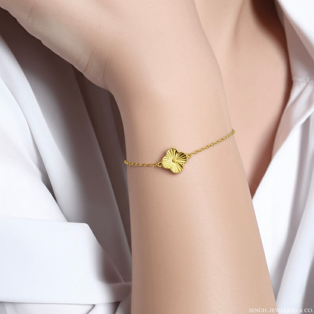 Yellow gold clover motif bracelet worn on wrist