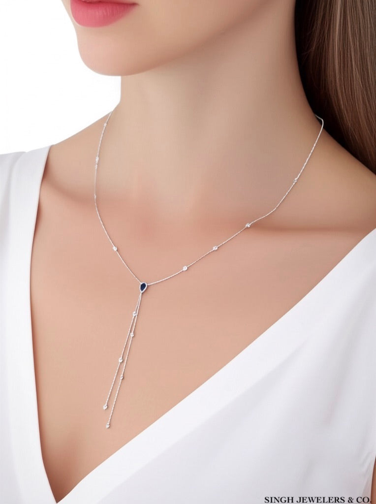 Silver necklace with a blue gemstone on a white background