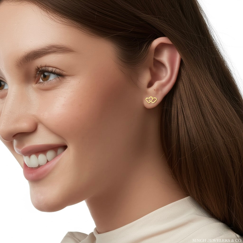 Woman wearing 10K gold heart stud earrings