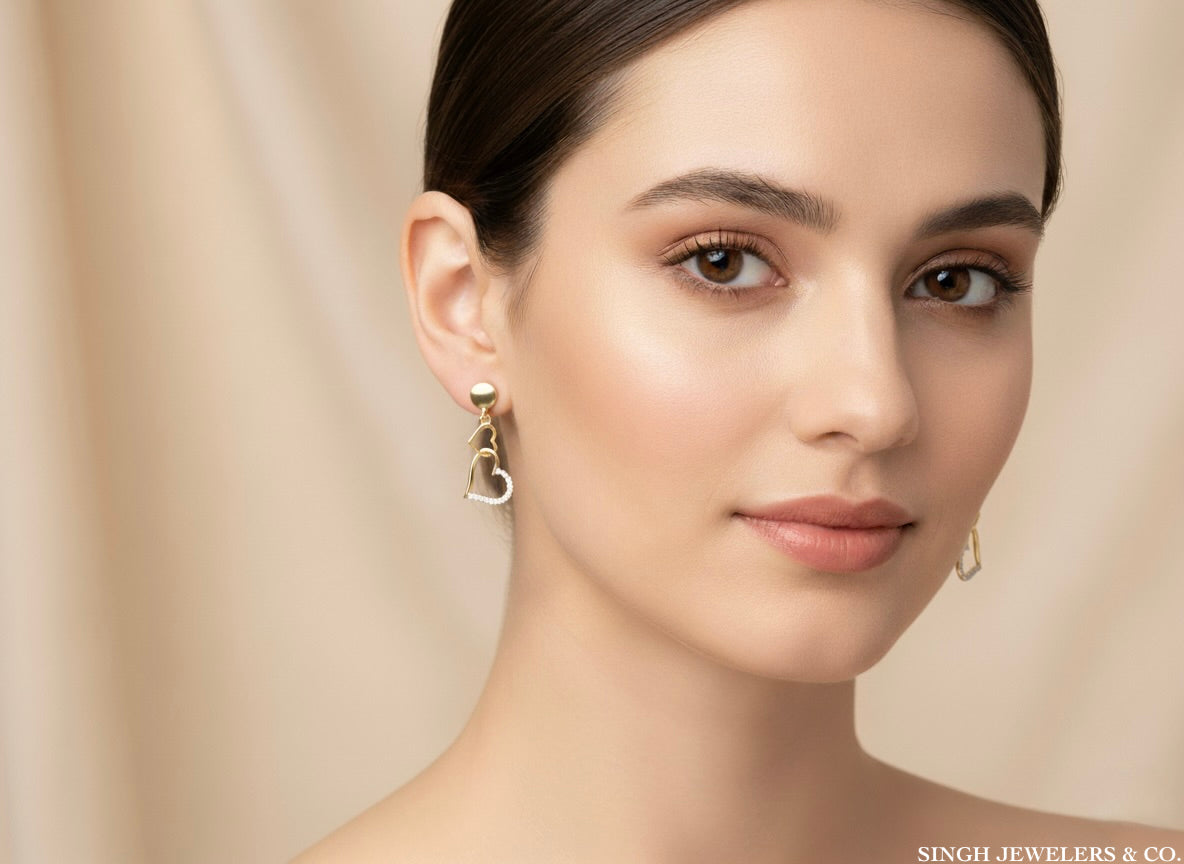 Woman wearing gold earrings with a neutral background