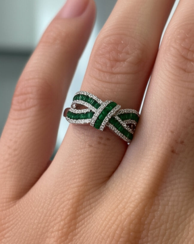 Sterling silver jewelry ring with white sapphires and green accents, bow design