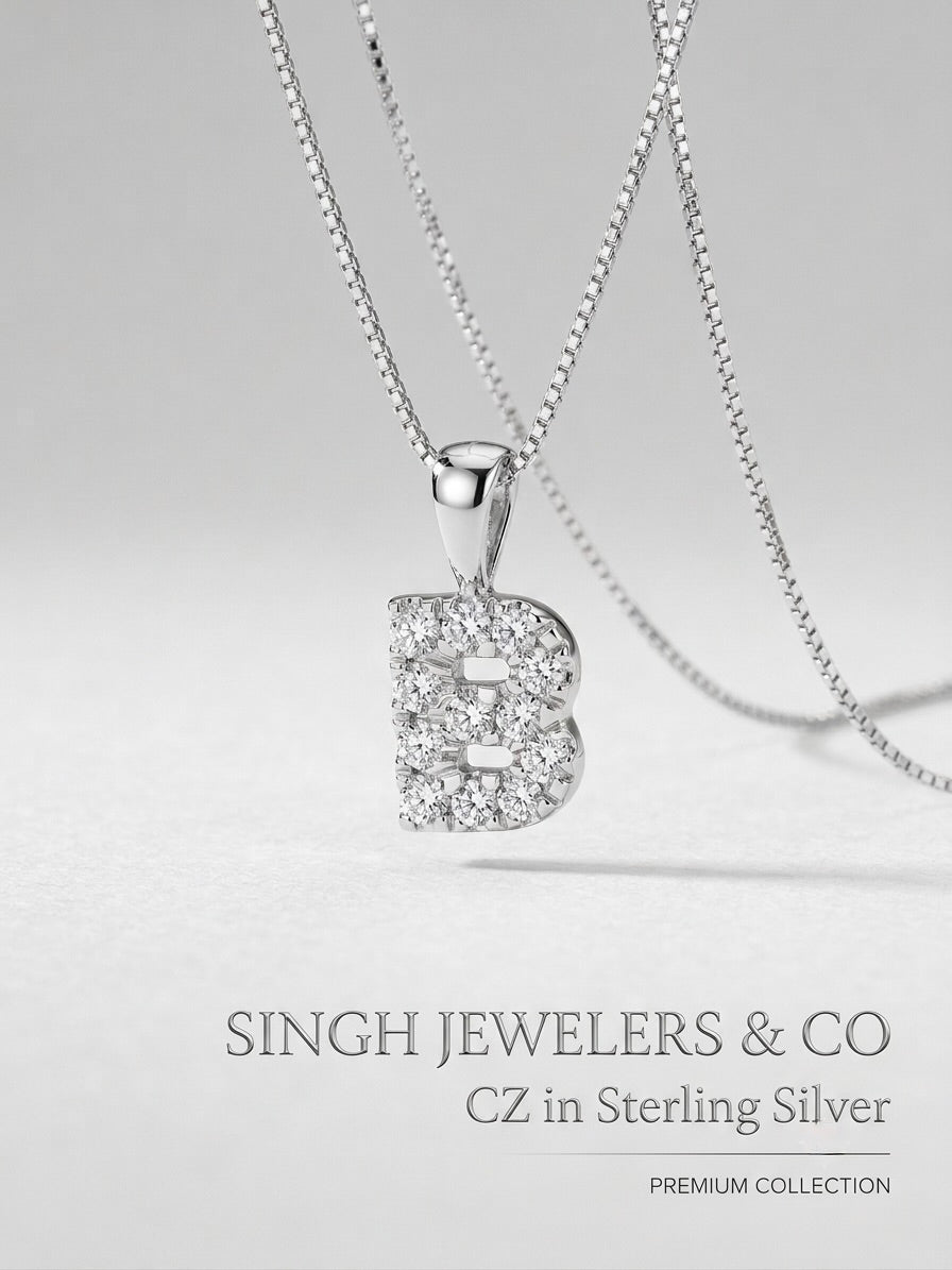 Silver necklace with a 'B' pendant on a light gray background, featuring Singh Jewelers & Co branding.