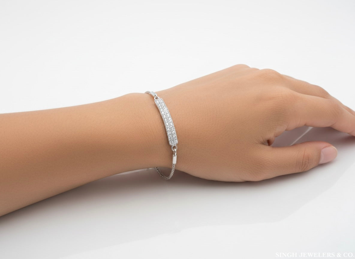 Hand wearing a silver bracelet on a white background