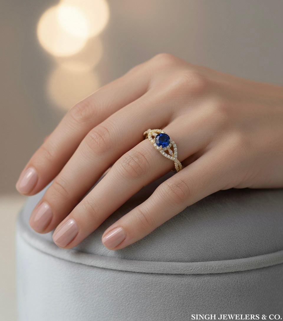 10k gold criss-cross ring with blue stone and white sapphires worn on female hand model