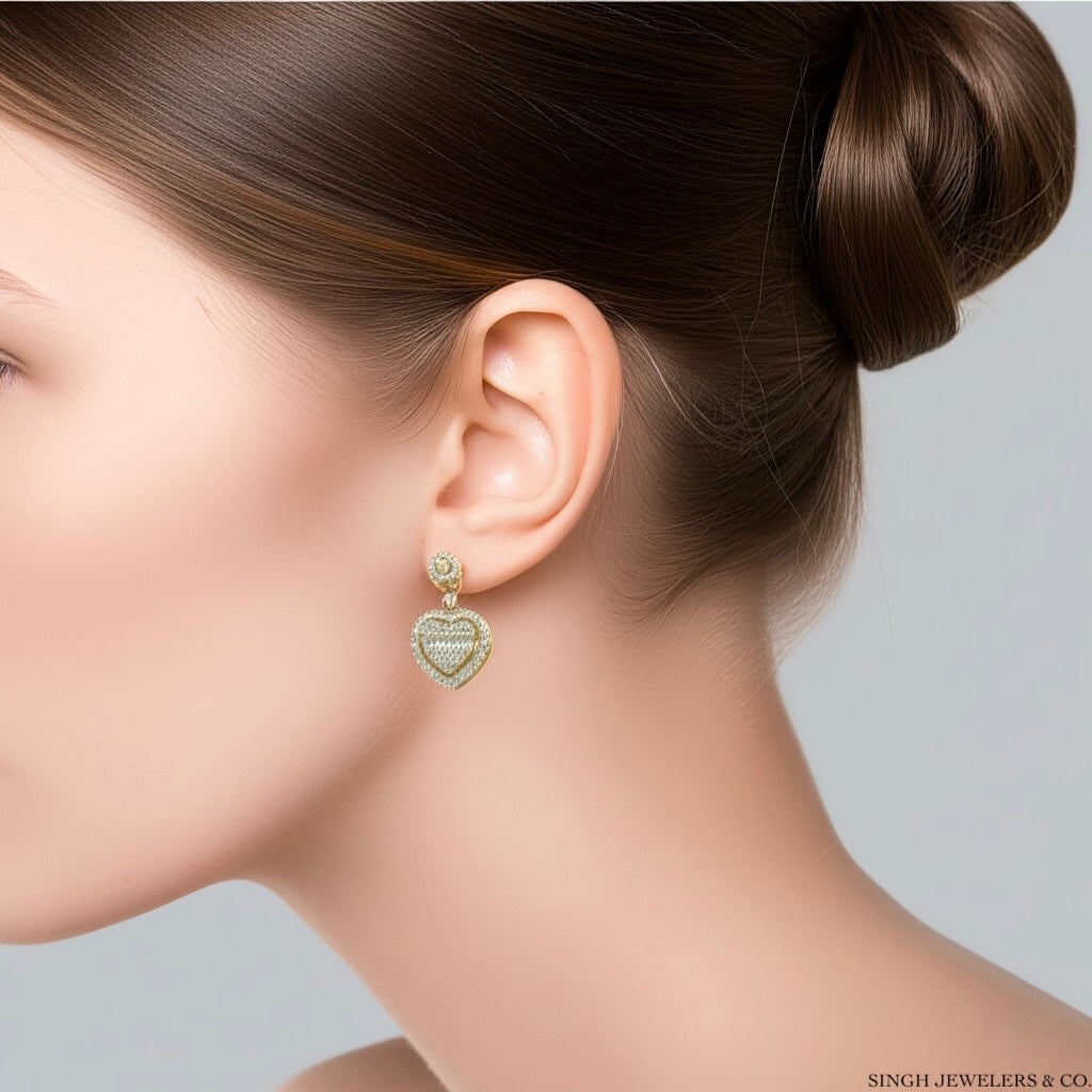 Woman wearing 10K gold heart baguette diamond earrings