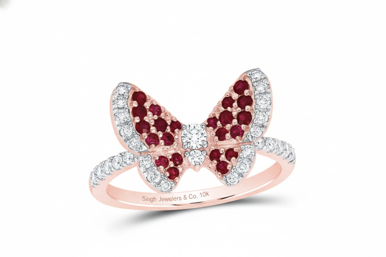 Close-up of round rubies and diamonds on 10K rose gold butterfly ring