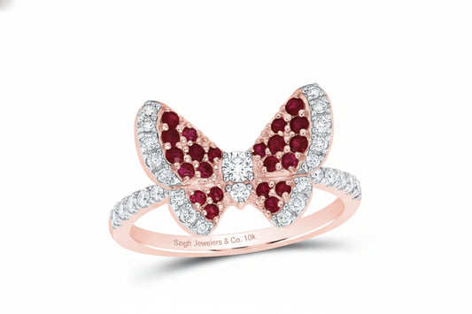 Close-up of round rubies and diamonds on 10K rose gold butterfly ring
