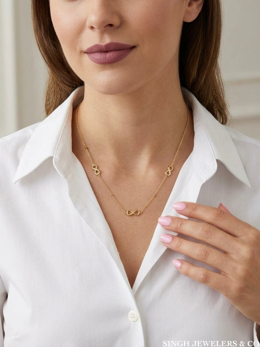 10K solid yellow gold triple infinity charms necklace around woman's neck.