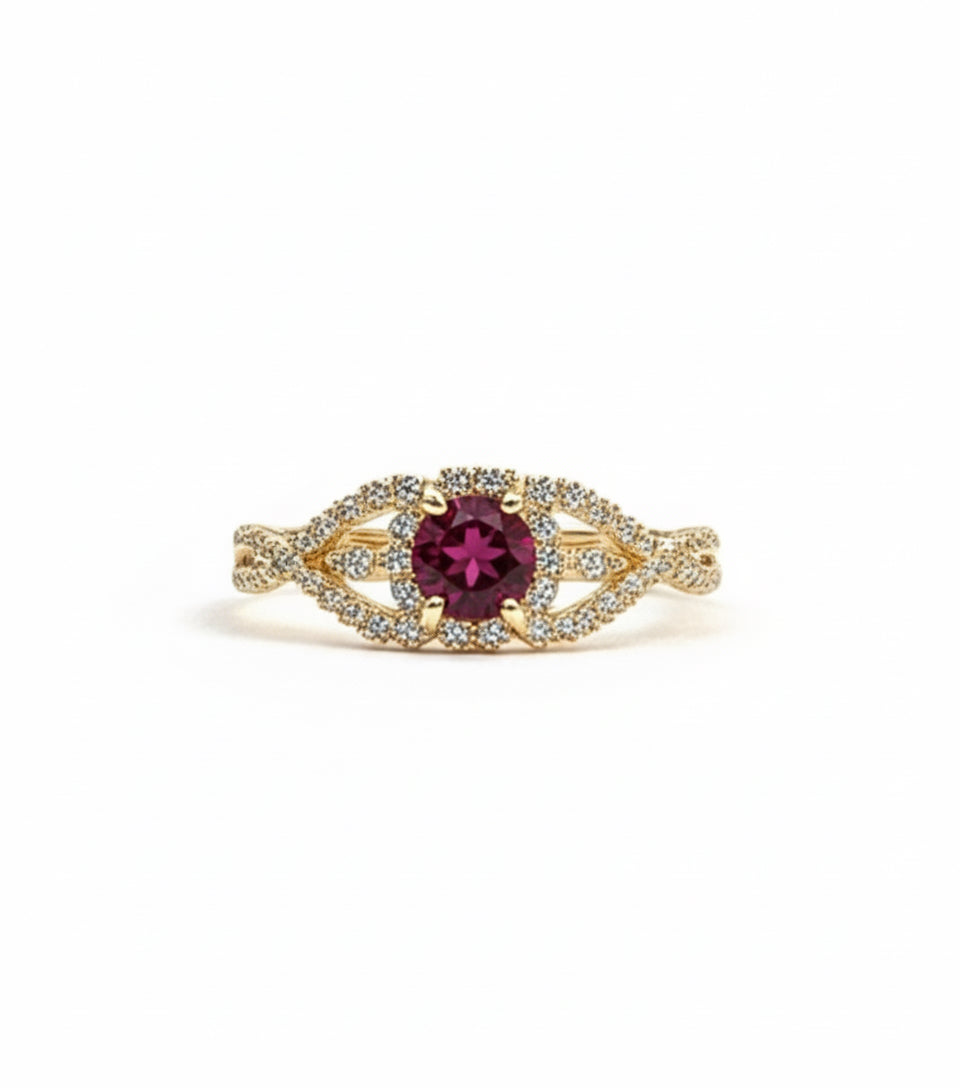 Gold ring with a red gemstone on a white background