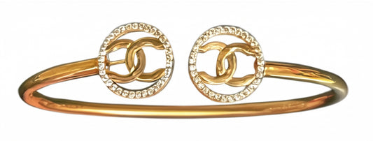 Elegant 10K yellow gold bangle featuring white sapphires in Chanel design