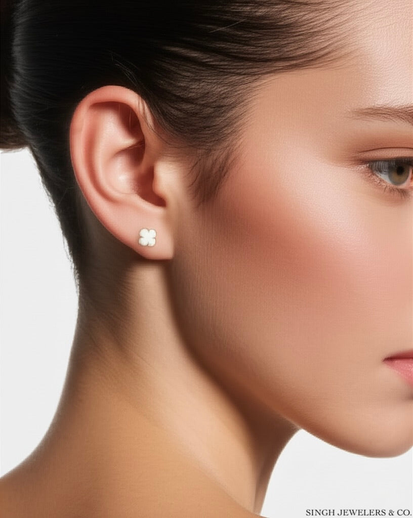 Model wearing 10k yellow gold clover earrings with white accents