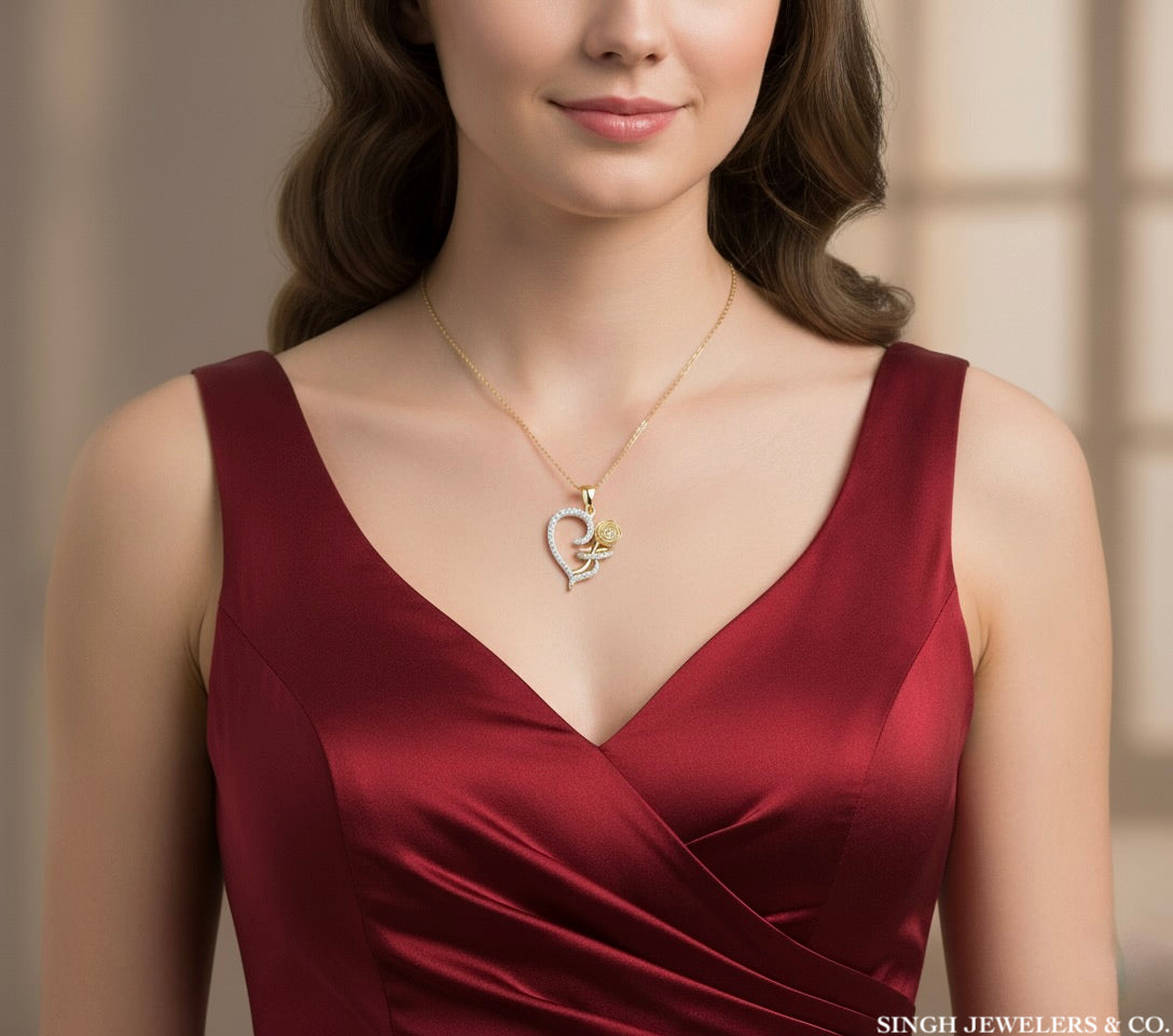 Woman wearing a gold necklace with a heart pendant, dressed in a red dress.