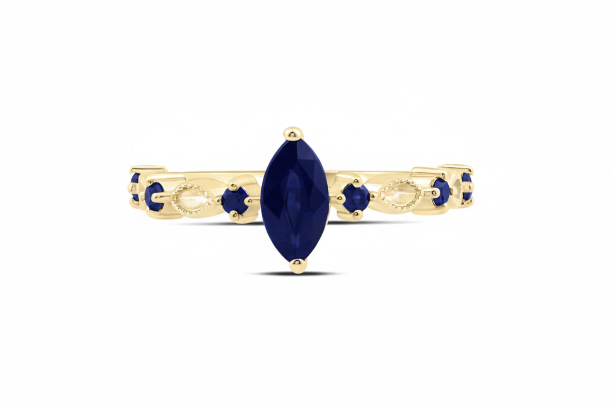 Gold ring with a marquise-shaped blue gemstone on a white background