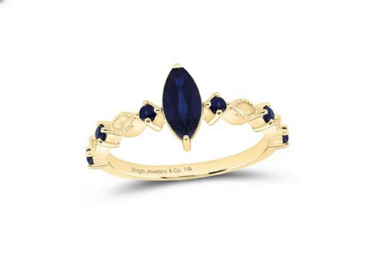 Gold ring with blue gemstones on a white background