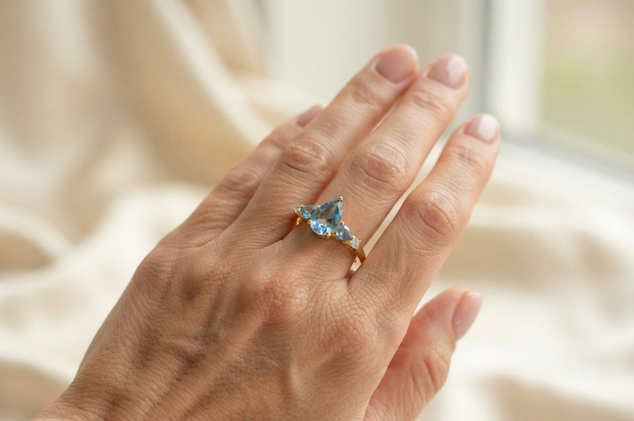 14K gold pear blue topaz and diamond ring worn on hand