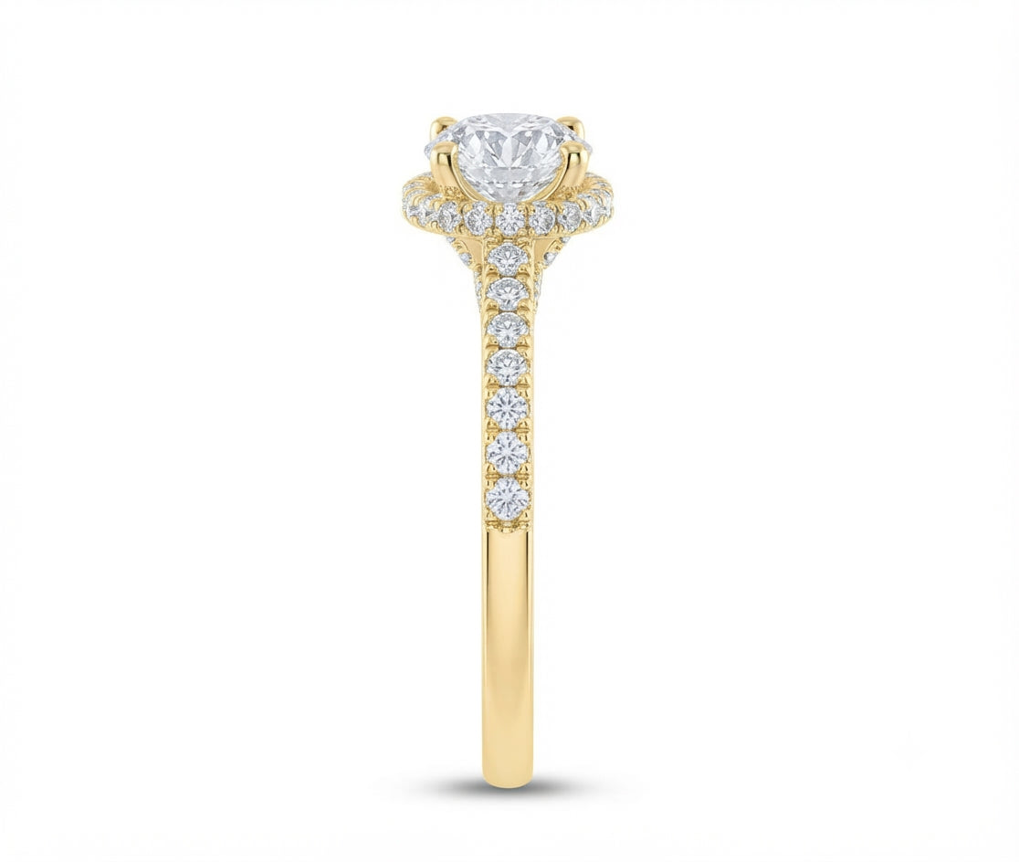 A yellow gold diamond ring with a round-cut center stone and a halo of smaller diamonds, set against a plain white background.