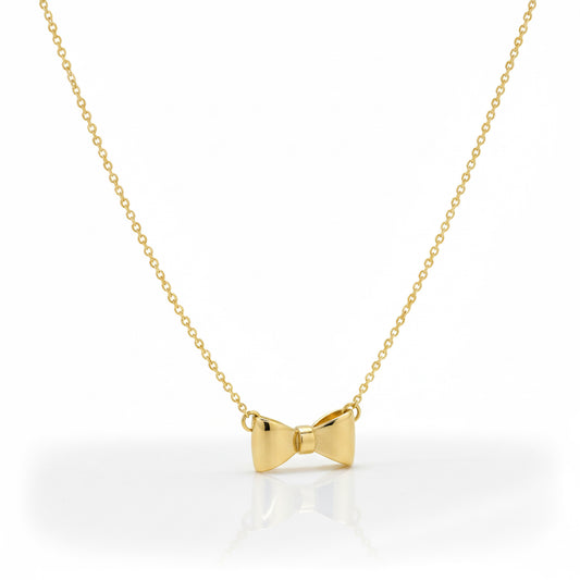 Gold bow-shaped pendant on a chain against a white background