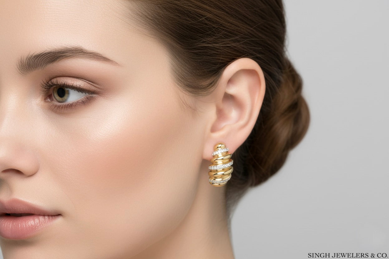 Gold earring worn by a model with a neutral background