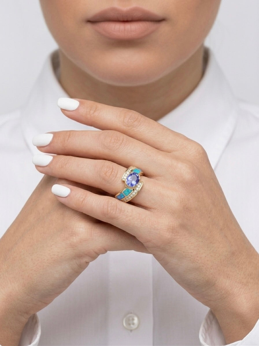 14K yellow gold ring featuring tanzanite, opal, and diamond gemstones worn on finger