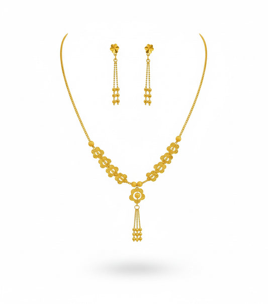 Gold necklace and earrings set on a white background