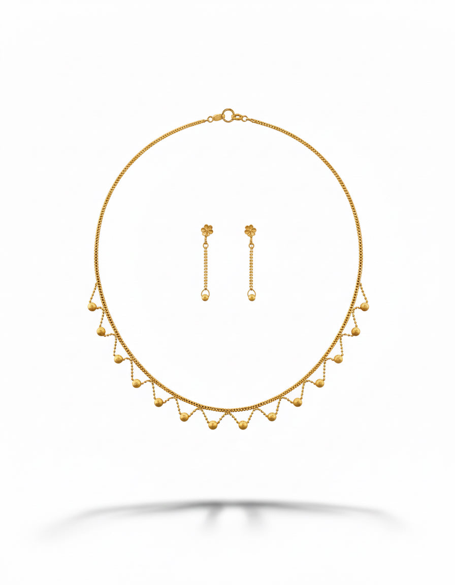 Gold necklace and earrings set on a white background