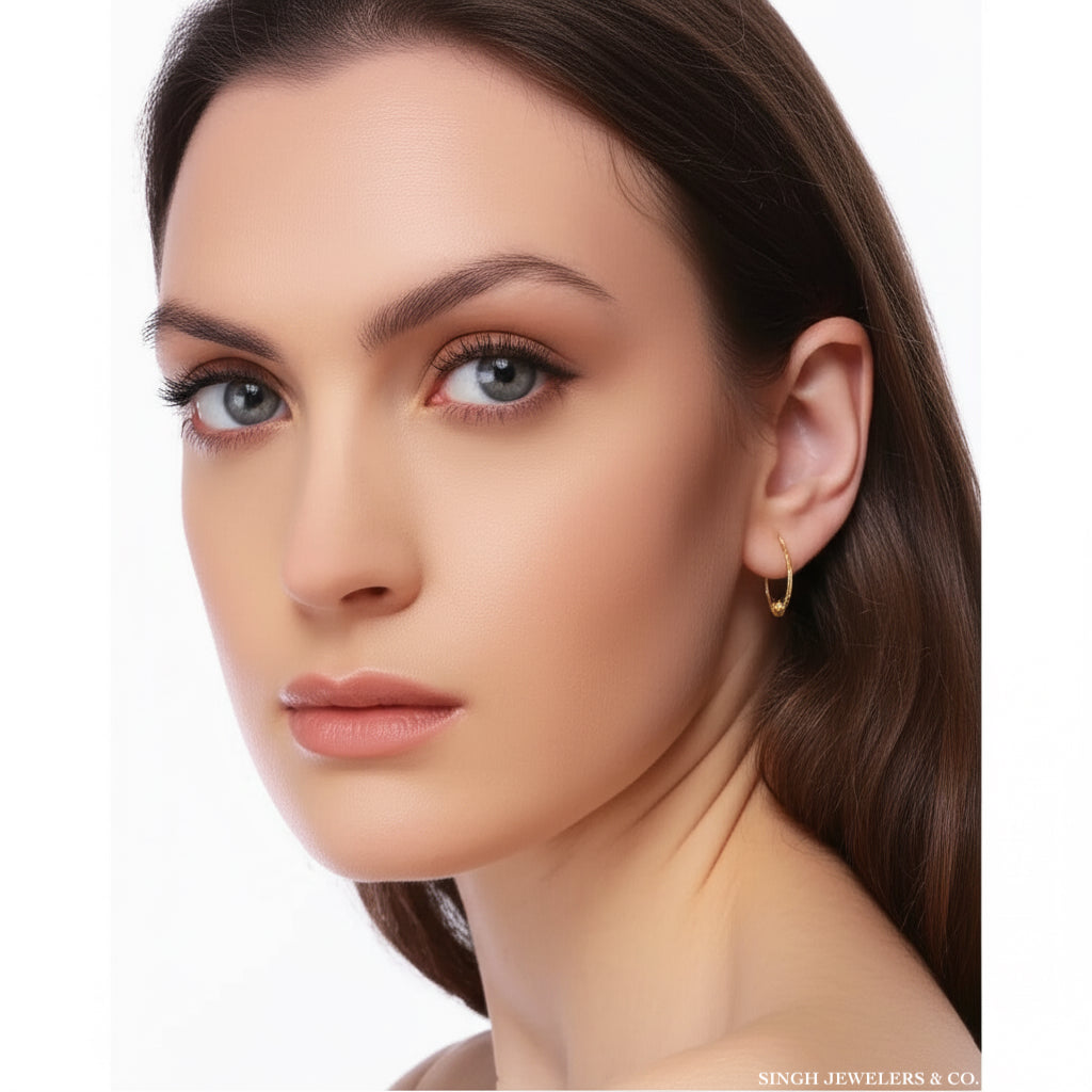 Close-up of a woman wearing a gold hoop earring on a white background