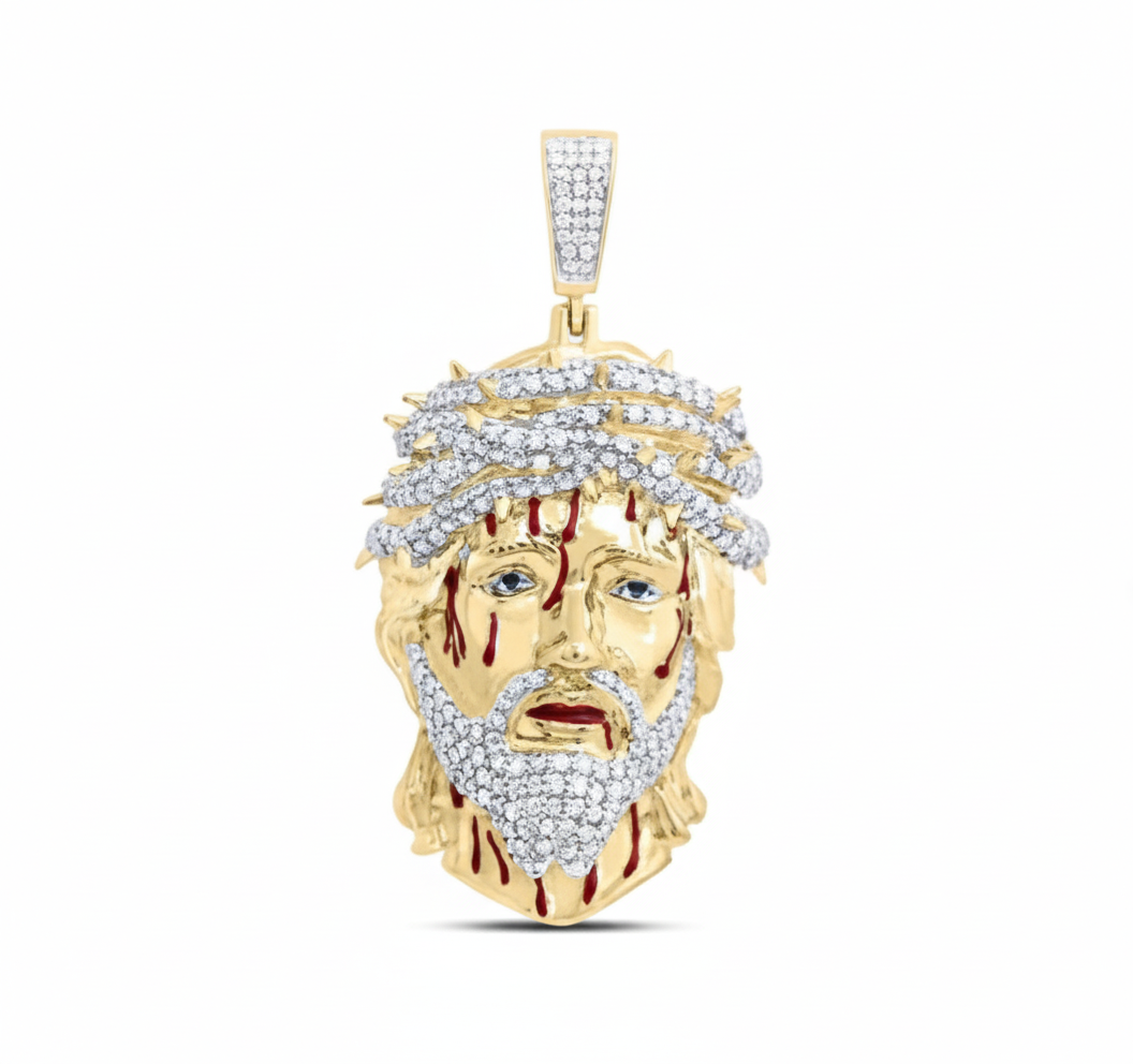 Gold pendant with a face design on a white background