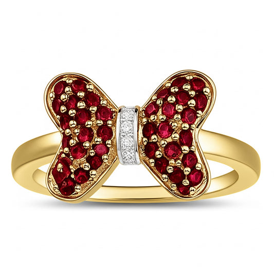 Gold bow-shaped ring with red gemstones and a white center on a white background