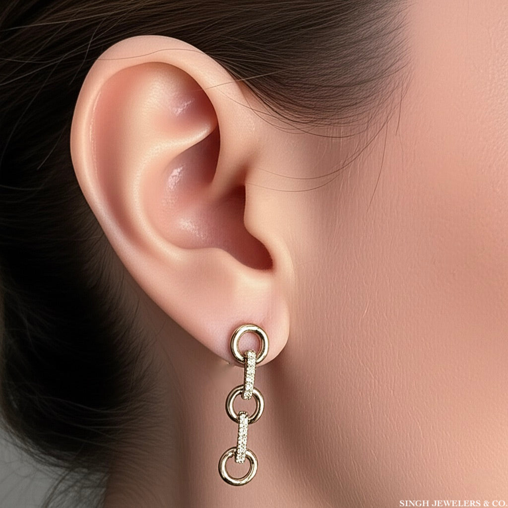Model wearing 14K yellow gold diamond link dangle hoop earrings with 0.20 CT sparkle