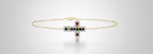 Gold bracelet with gemstone accents on a light gray background