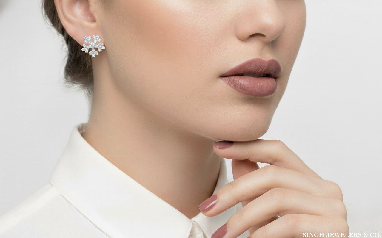 Close-up of a woman wearing snowflake earrings with a neutral background
