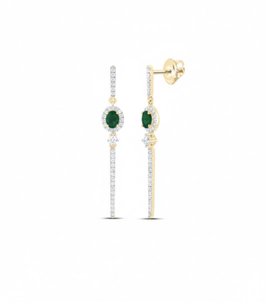 Gold earrings with green gemstones on a white background