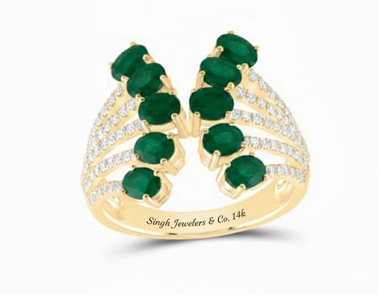 Gold ring with emeralds and diamonds on a white background
