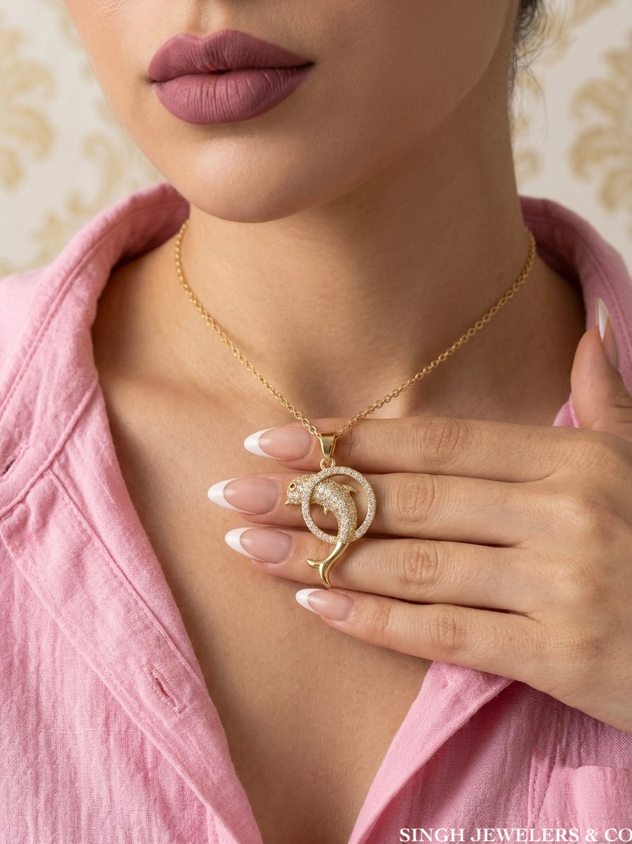 Ocean-inspired gold tone dolphin necklace with cubic zirconia accents and 18-inch chain