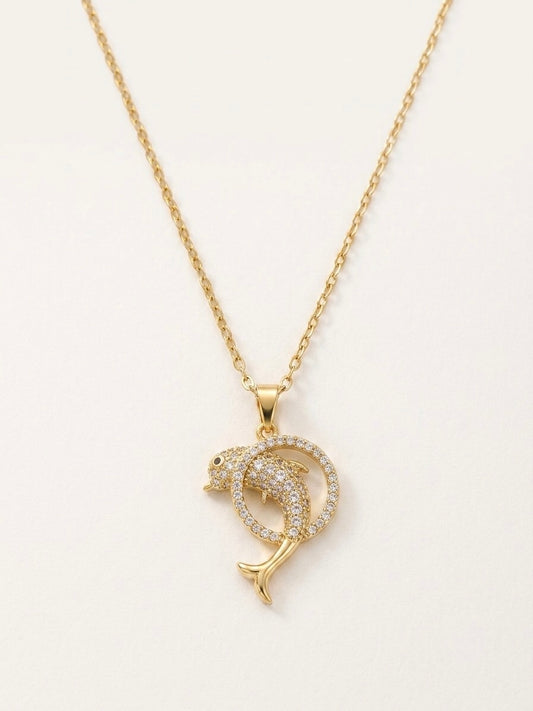 Gold dolphin pendant necklace on a white background