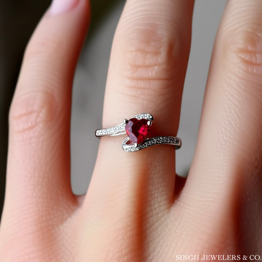 Sterling silver heart-shaped ruby ring worn on female hand