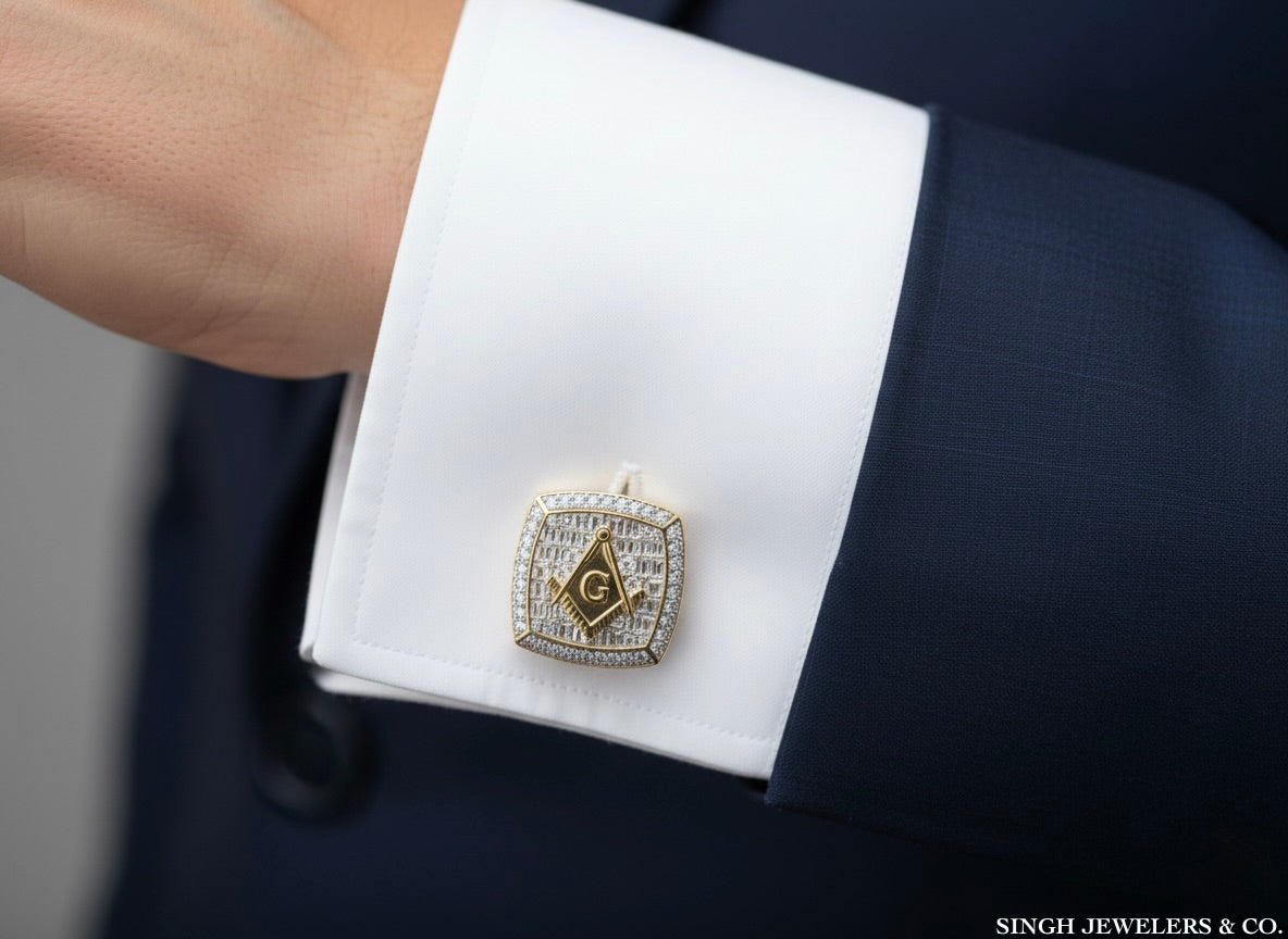 Gold Masonic cufflink on a white cuff against a navy suit background, with 'Singh Jewelers & Co.' branding.